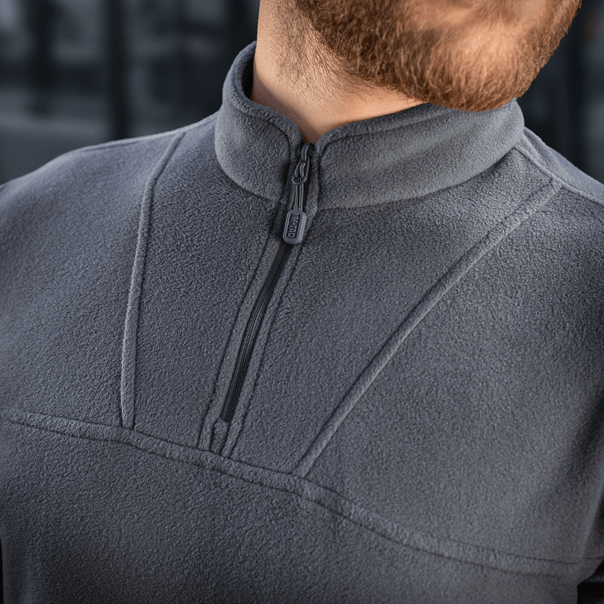 Mand iført M-Tac Delta Polartec Fleecejakke i grå farve med halv lynlås, stilfuldt design for kolde temperaturer.
