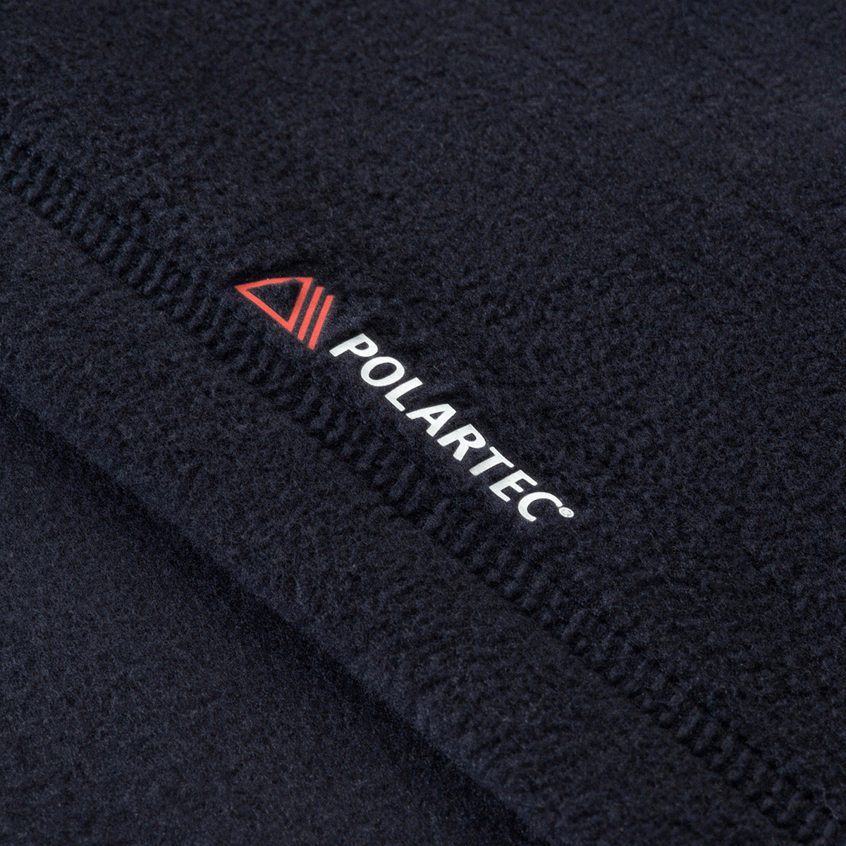 Detalje af M-Tac Delta Polartec Fleecejakke lavet af Polartec® Micro Series-fleece, viser det bløde materiale og trademark logo.