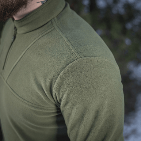 M-Tac Delta Polartec Fleecejakke i grøn med halv lynlås, ideel til kolde dage og lavet af slidstærk, åndbar Polartec® Micro Series-fleece.