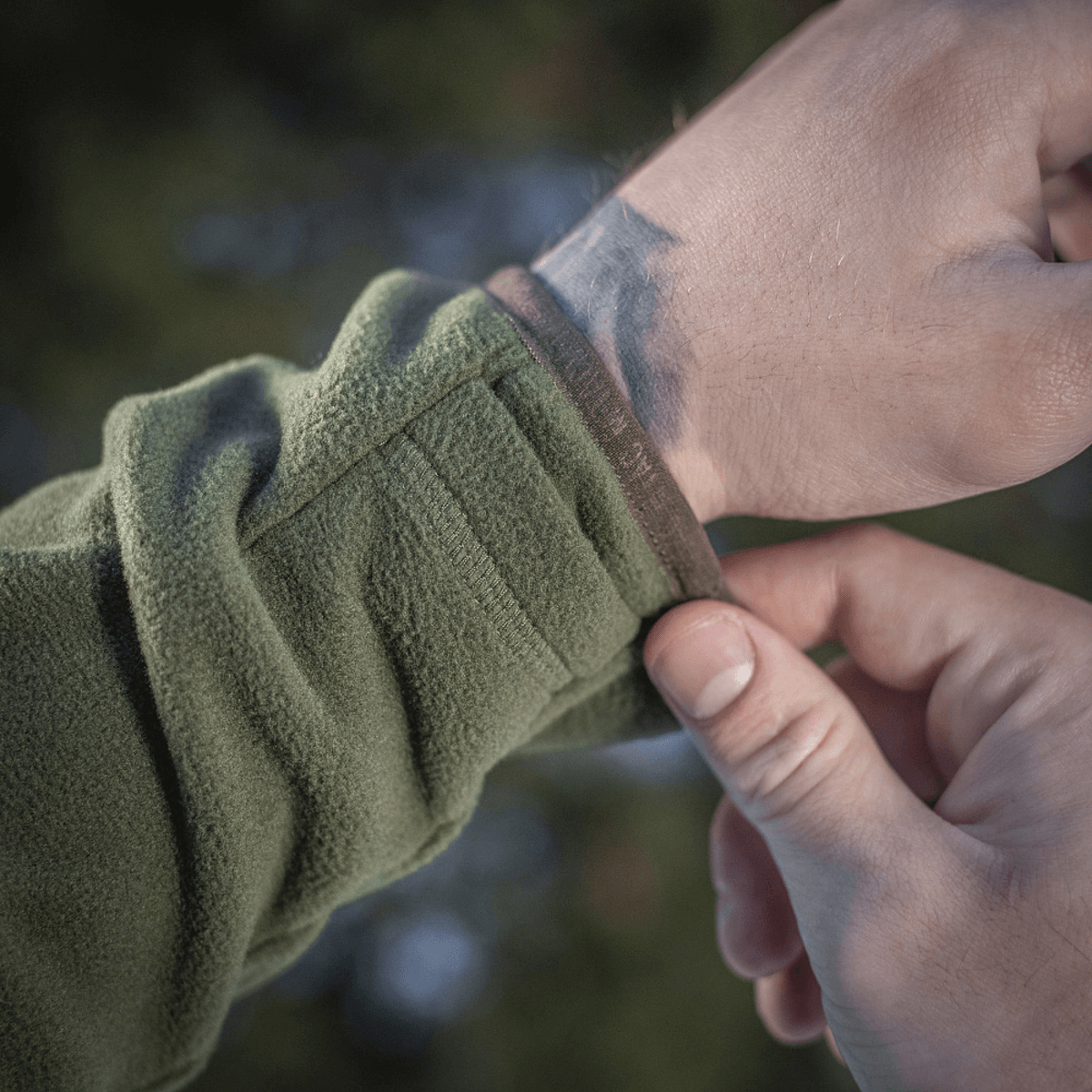 Nærbillede af justering af M-Tac Delta Polartec Fleecejakke med grøn fleece stof og praktisk lynlåsdetalje.