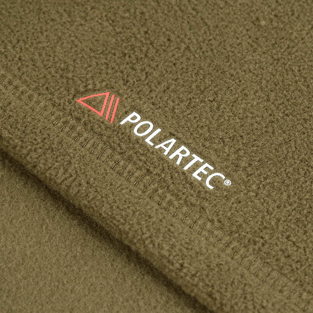 Nærbillede af M-Tac Delta Polartec Pullover Dame med Polartec logo, grøn farve og varmende fleece materiale.