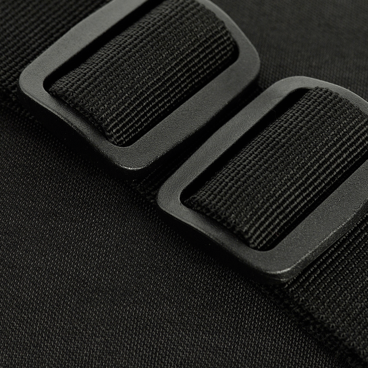 Nærbillede af spænder på M-Tac Assistant Taske, der viser kvaliteten og holdbarheden af stropmaterialet til daglig brug.