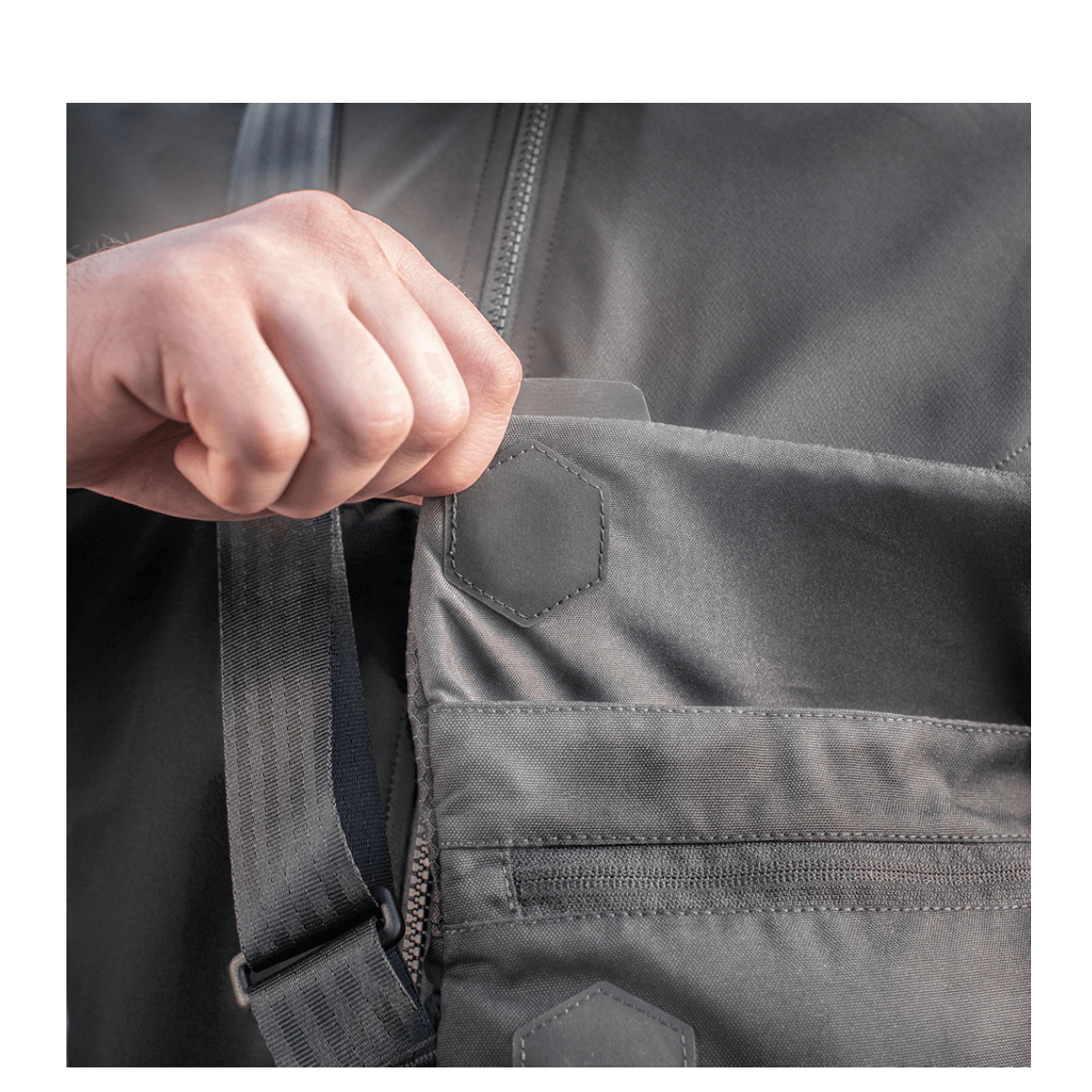 Hånd åbner magnetventil på M-Tac Konvert Taske Elite fremstillet af Cordura-materiale.