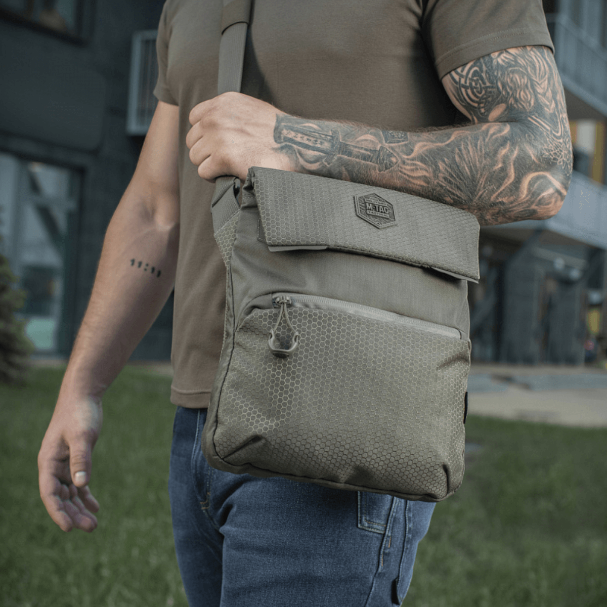 M-Tac Konvert Taske Elite båret af person udendørs, fremstillet af slidstærk Cordura 500D og Cordura Hex 1000D, justerbar skulderrem.