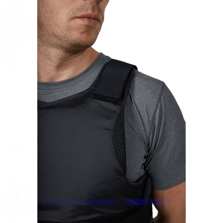 Anorak Rhodium® Concealable II Stick- & Skottsäker Vest buren av man i grå tröja, visar diskret och starkt skydd, nivå Level IIIA.