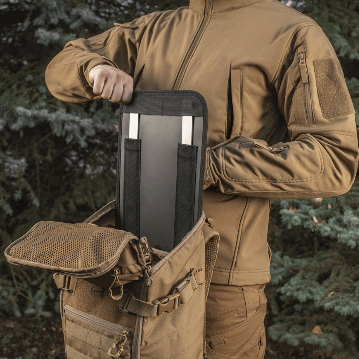 Person pakker M-Tac Rygsæk Gen. II Elite – Small med stivhedsstøtteindsats.