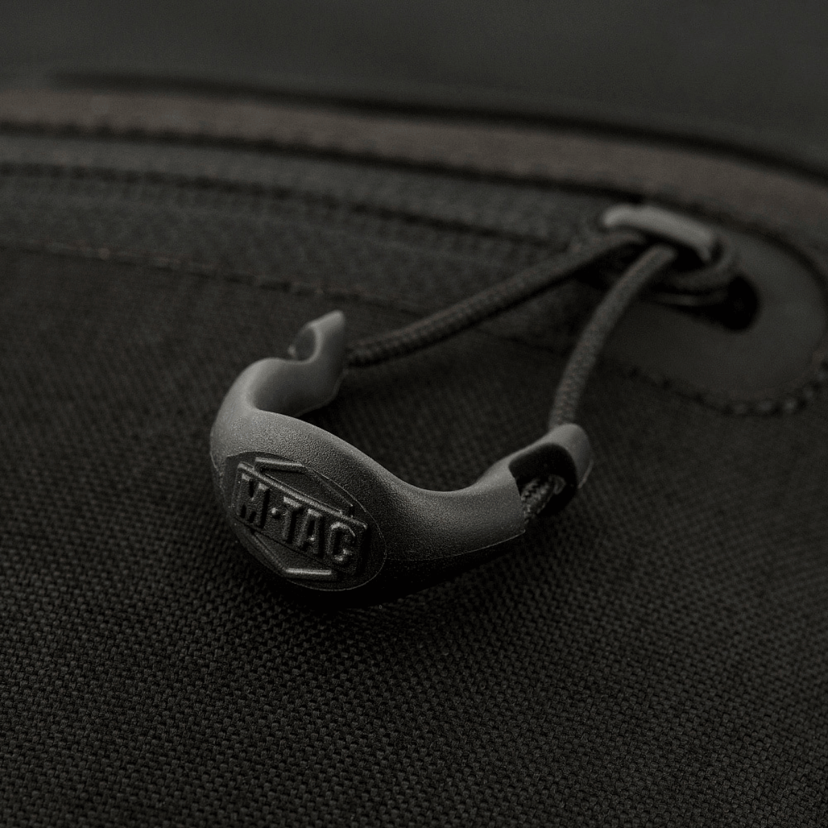 Lukning af M-Tac organizer pouch Elite, viser detalje af lynlåsstrop i sort materiale, ideel til taktisk udstyr.