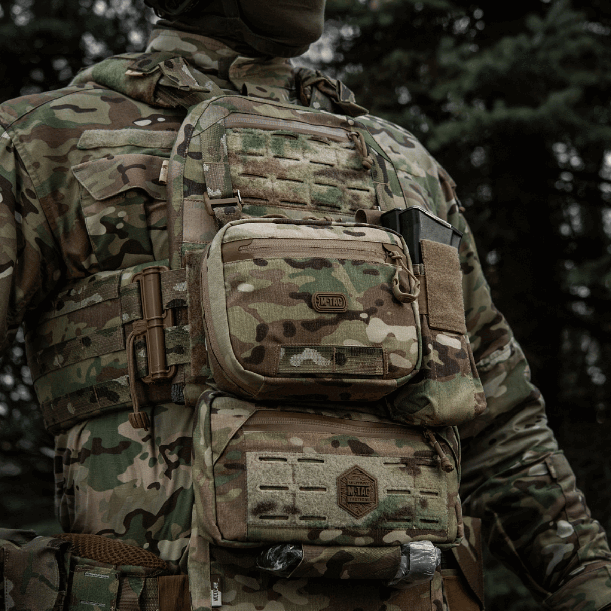 M-Tac organizer pouch Elite fastgjort til en taktisk vest i skovkamuflage, designet til at bære førstehjælpsudstyr og EDC-sæt.