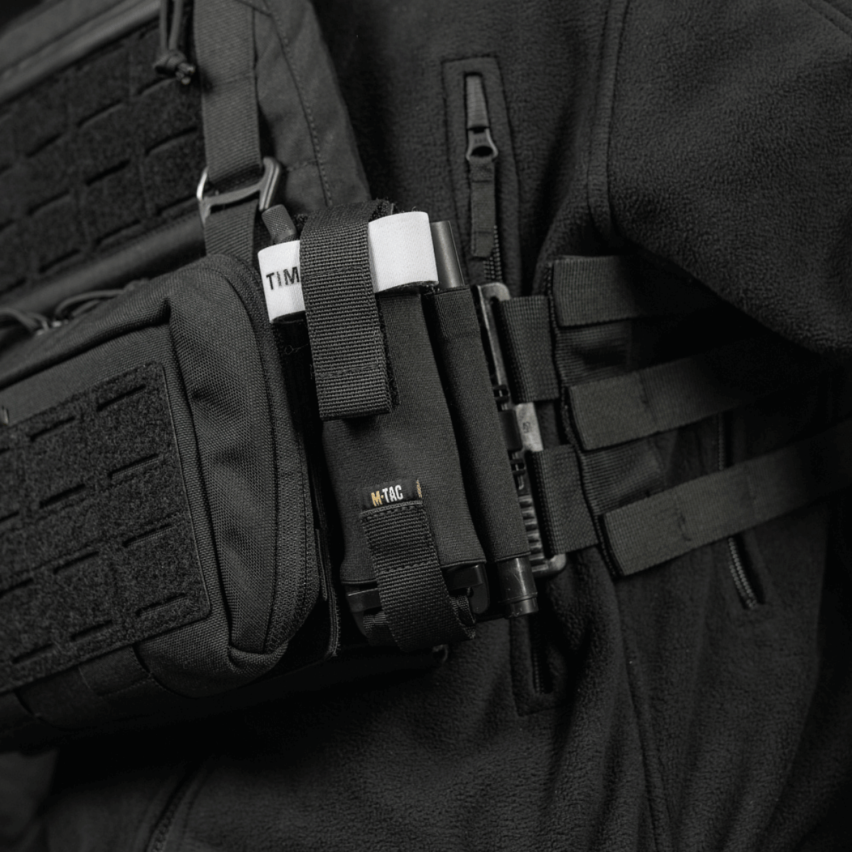 M-Tac Elastisk Tourniquet Holder Gen. III monteret på soldats udstyr, robust Cordura 500D, sikrer C-A-T tourniquet med elastik og Texcel-webbing.