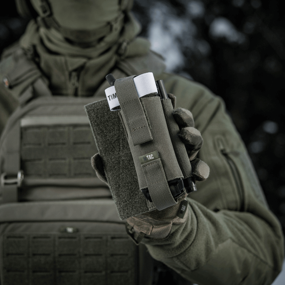 M-Tac Elastisk Tourniquet Holder Gen. III i brug af soldat, fremstillet af slidstærk Cordura 500D, modstandsdygtig og praktisk.