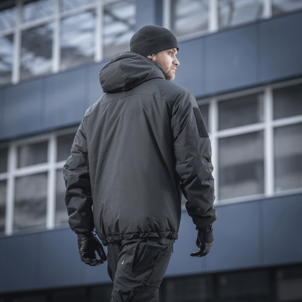 M-Tac Alpha Gen.III Pro Vinterjakke i sort, set bagfra på en mand i byen, designet til ekstrem kulde og regn, forbedret med G-Loft fyld.