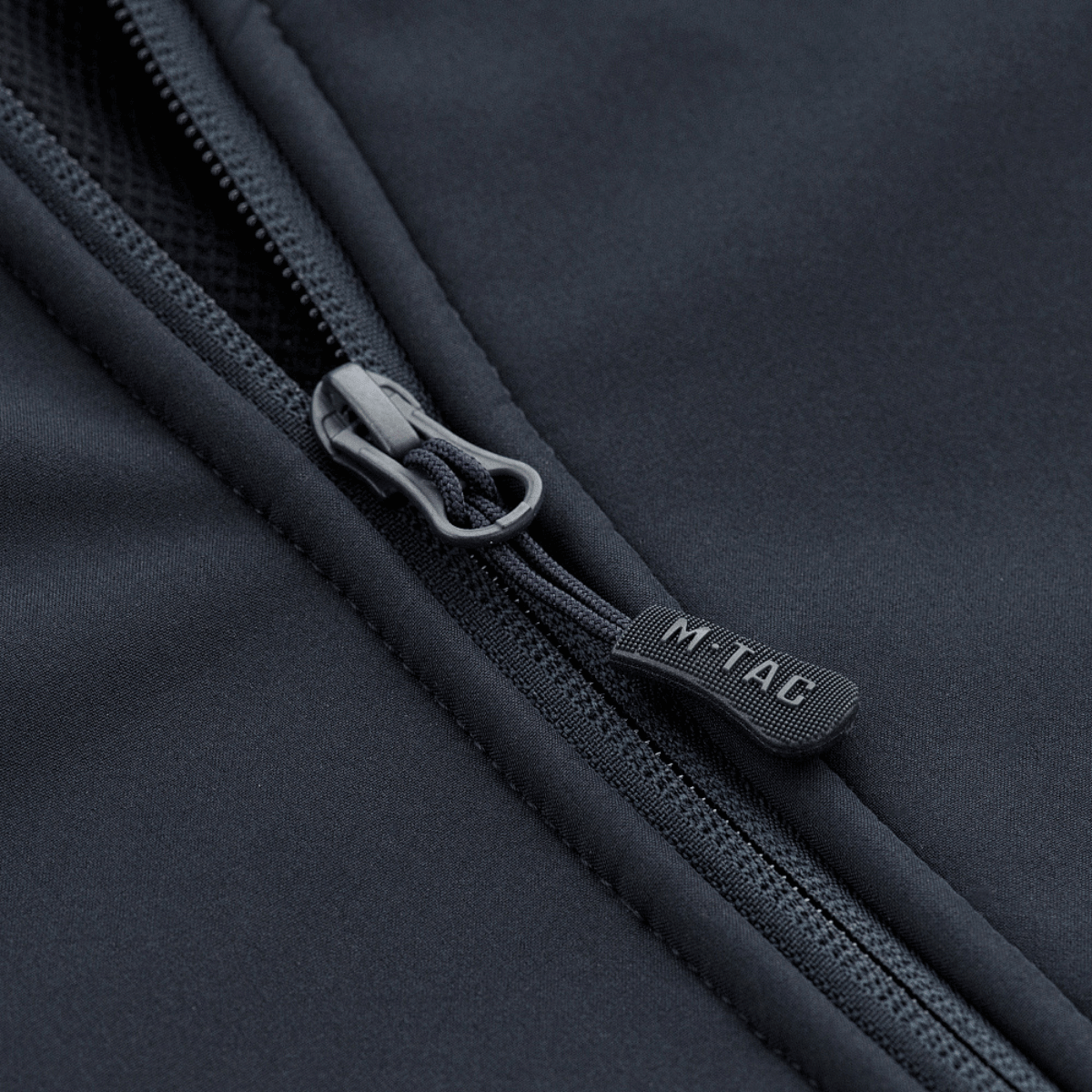 Detalje af lynlås på M-Tac Soft Shell Jakke med Liner, der viser robust design og kvalitetsmaterialer for vejrforsvar.