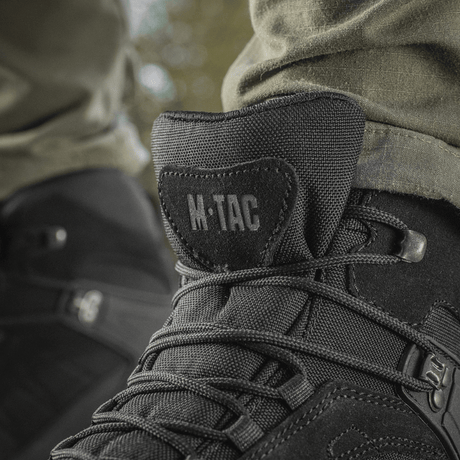 M-Tac Taktiska Säsongsstövlar i svart läder för utomhusbruk, detaljbild av snören och logotyp.