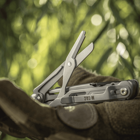 M-Tac Type 3 Foldekniv (5-i-1) Rostfritt stål med verktygsvisning, inklusive saxfunktion, i naturlig EDC-miljö.