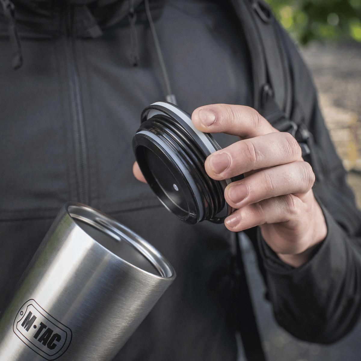 M-Tac Termokop 450 ml med Ventil i rustfrit stål vises med låget fjernet for at fremhæve dens design og funktion i praktisk brug.