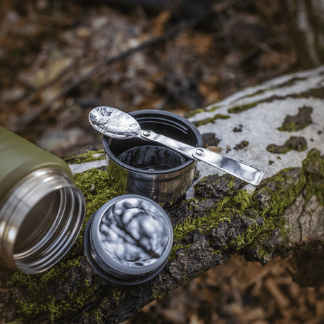 M-Tac termosflaska 750 ml med hopfällbar sked i naturen, rostfritt ståldesign med sked på trä, idealisk för camping och utomhusbruk.