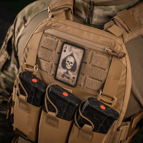 M-Tac Patch Ace of Spades på en militärväst i vintagestil, visar spar ess dödskalle‑design. Robust Cordura 500D med Velcro‑montering.