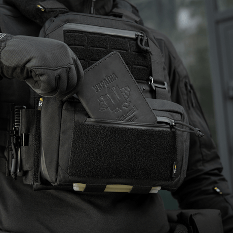 M-Tac Admin Pouch Large Elite Gen.II i användning med pass i frontfickan, visar robusthet och praktisk design för personliga ägodelar.