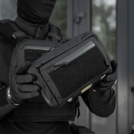 Person håller M-Tac Admin Pouch Large Elite Gen.II, designad för effektiv förvaring med robusta material och modulära tillbehörsmöjligheter.