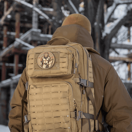 M-Tac Deus Vult 3D PVC-patch monterad på en taktisk ryggsäck i vinterlandskap.