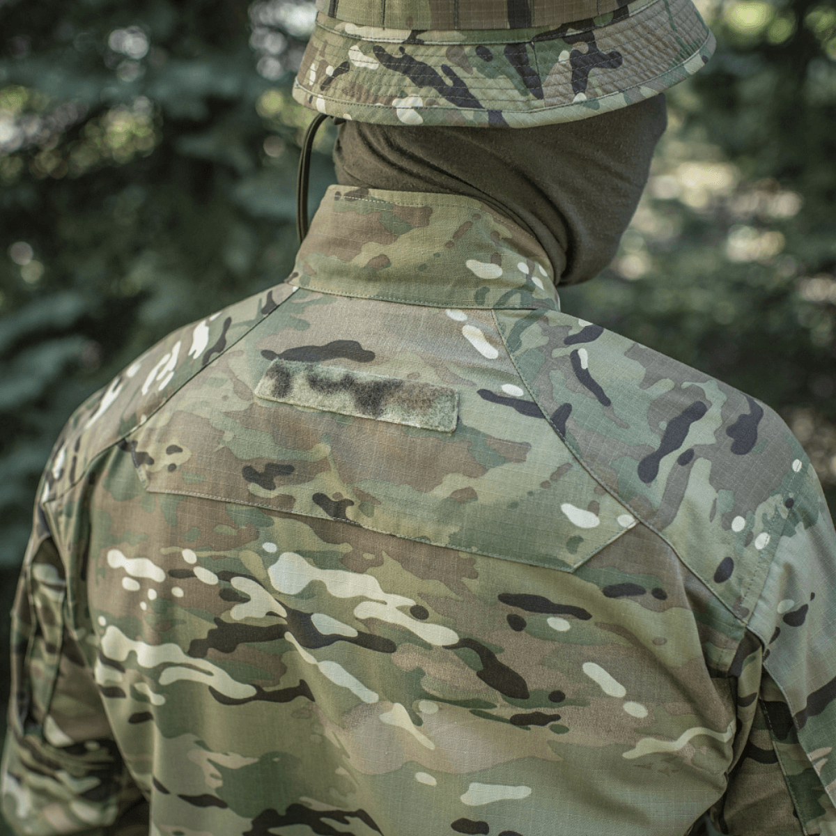 M-Tac Jakke Sturm Gen.II NYCO Extreme i Multicam camouflage til taktisk brug, set bagfra i skovmiljø.
