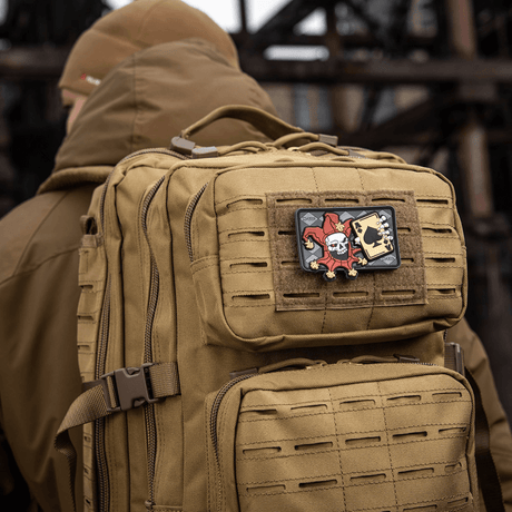Taktisk ryggsäck med M-Tac Patch Joker Skull 3D PVC med joker och dödskort i PVC, monterad på ryggsäckens framsida.