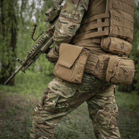 Soldat med M-Tac Pouch til M249 Cartridge Box Closed fäst på taktisk väst i fältmiljö, visar hållbarhet och funktionalitet