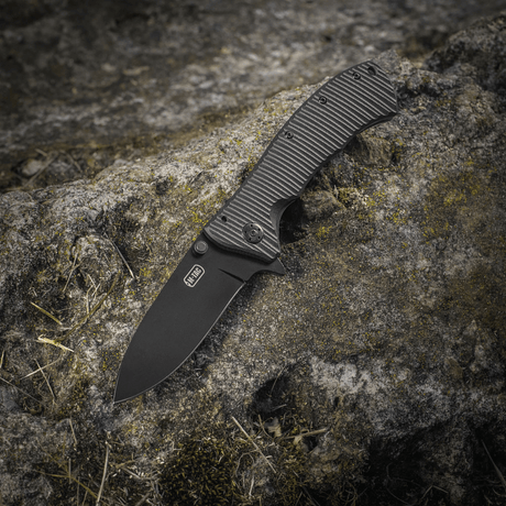 M-Tac Outdoor & Militär fällkniv - Type 7 på klippa, lättviktsdesign med svartbelagt 5Cr15MoV-blad och frame-lock.