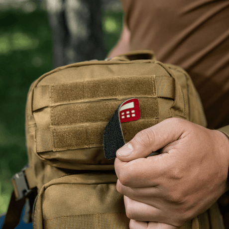 M-Tac Patch Flag 25x80 Mini Squares på en väska, hålls av en person. Cordura 500D, Velcro-montering, laser cut, slitstark och lätt patch.
