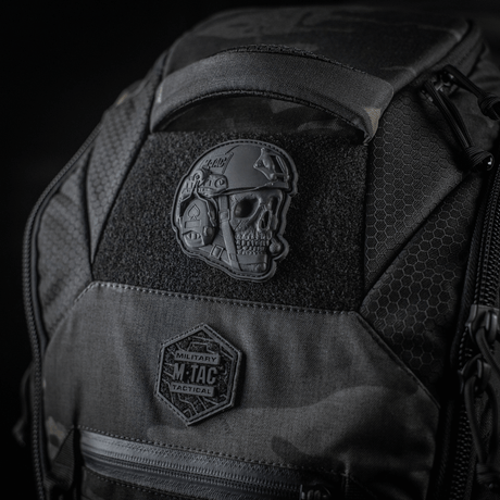 M-Tac Patch Operator 3D PVC monterad på en taktisk ryggsäck med Velcro, realistisk design, idealisk som morale patch. Storlek: 6 x 7 cm.