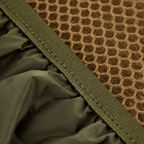 Närbild av M-Tac ryggsäcksskydd i nylon med PU-beläggning, visar vattenavvisande material och nätstruktur för skydd mot regn och snö.