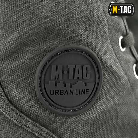 Nærbillede af M-Tac Sneakers med klassisk design og holdbart bagoverlay for udendørs brug, fokus på metalliserede snørehuller.