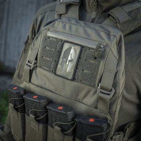 M-Tac Spartan Hjelm Patch på taktisk väst, symboliserar mod och styrka, gjord av Cordura 500D i vintage‑look med Spartan‑hjälm.