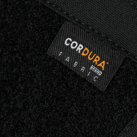 Närbild av Cordura-etikett på M-Tac Sphaera Hardsling Bag Large Elite med Velcro, tillverkad av hållbara material.