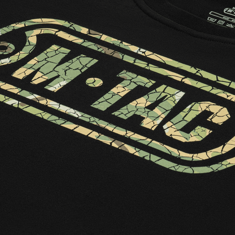M-Tac T-Shirt Logo med moderne camouflagemønster, ikonisk logo, og slogan på ærmet. Komfortabel og blød bomuldsblanding.