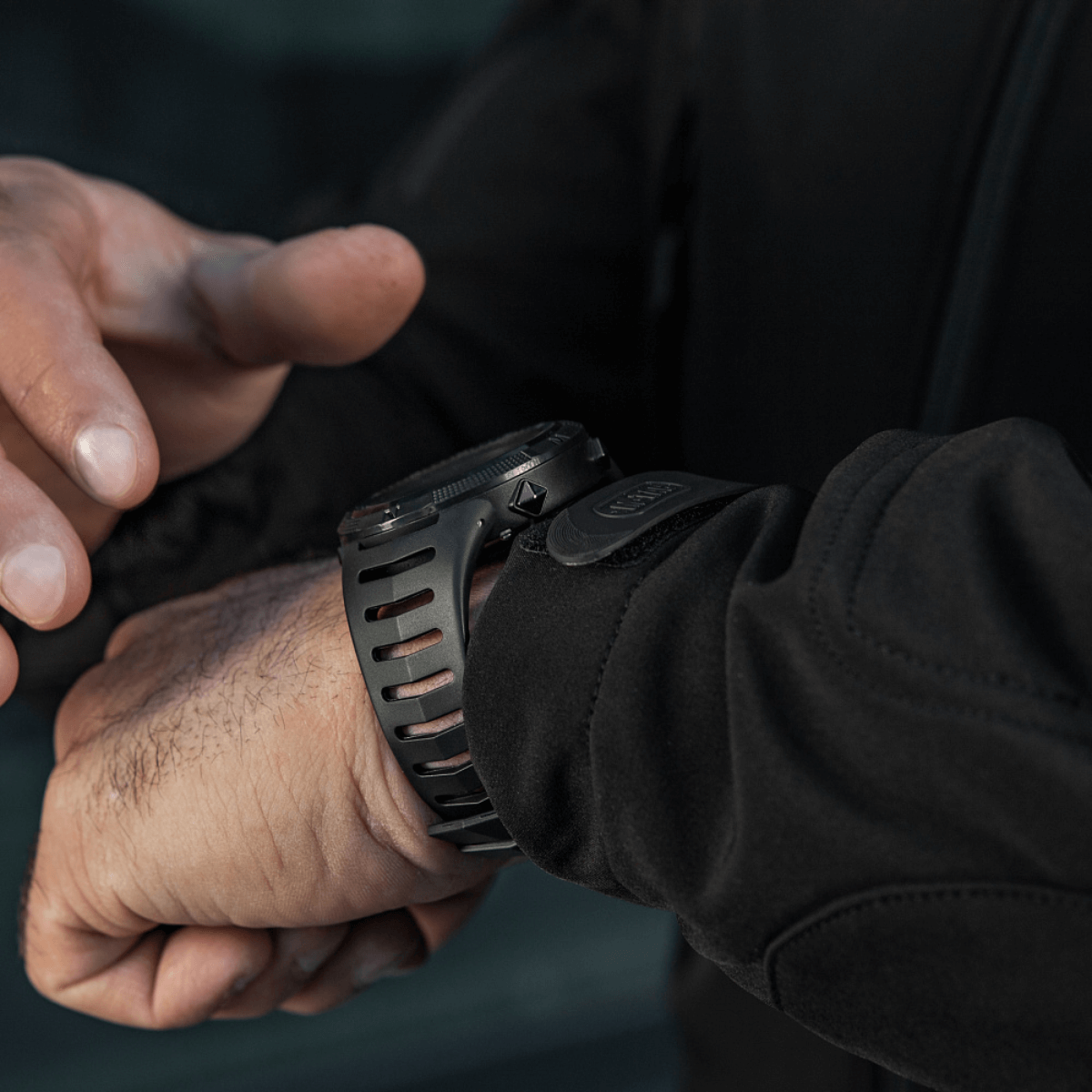 Person justerer M-Tac Tactical Ur 2147 på håndled. Ideel til outdoor og taktisk brug med robust design og praktiske funktioner.