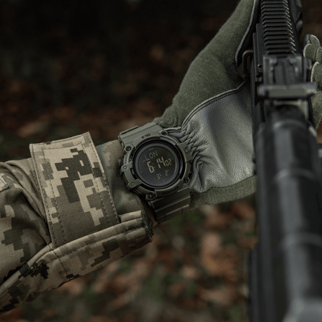 M-Tac Tactical Klocka med Kompass 2233 bärs av soldat i skogen, visar funktionalitet för friluft och taktisk användning, med robust design och kompass.