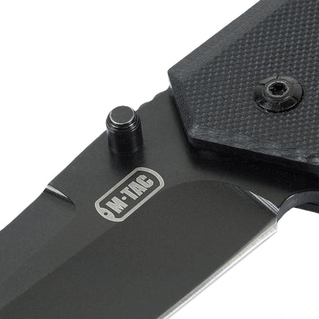 M-Tac Outdoor & Militär fällkniv - Type 5 med G10-komposithandtag i närbild, visar rostfri stålklinga och logotyp.