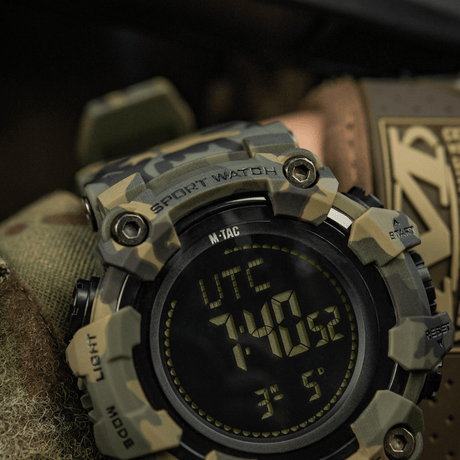 M-Tac Tactical Ur 2037 i robust camouflagedesign med LED-bakgrundsbelysning och funktioner som kompass och stoppur. Idealisk för utomhus och taktisk användning.