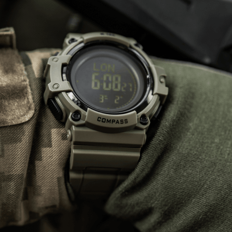 M-Tac Tactical Klocka med Kompass 2233 på kamouflagemanchett, robust design med LED-bakgrundsbelysning och kompass, idealisk för friluft och taktisk användning.