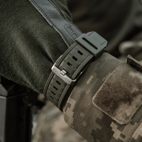 M-Tac Tactical Klocka med Kompass 2233 på soldats handled, robust klocka för taktisk användning och friluftsaktiviteter.