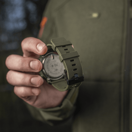 M‑Tac Multifunktionellt Taktiskt ur i robust design med grön rem, idealiskt för friluftsliv och militärt bruk. Hållbar och avancerad utrustning