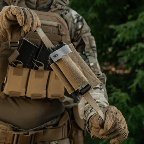 Taktisk udstyr med M‑Tac Tourniquet Pouch Elastic Gen.5 monteret til hurtig adgang på kamuflageuniform.