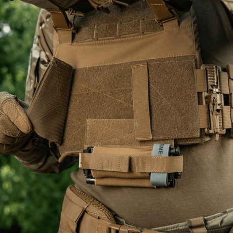 M‑Tac Tourniquet Pouch Elastic Gen.5 fastgjort til taktisk udstyr, viser elastisk fastgørelse og frontvelcro placering.