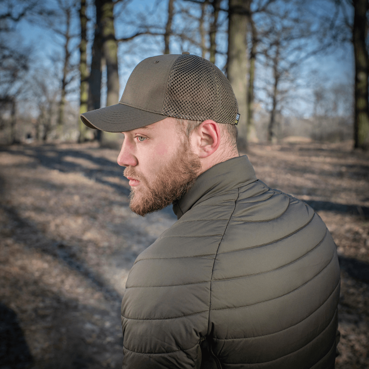 Mand bærer M-Tac Mesh Flex Ripstop Baseball Cap i skoven, viser ventilationsvenlig mesh-konstruktion og holdbar Ripstop-front.