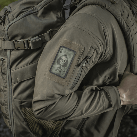 M-Tac Patch Ace of Spades monterad på jacka, Cordura 500D‑material, vintagelook, symbol för stridsanda och klarhet, Velcro‑montering.