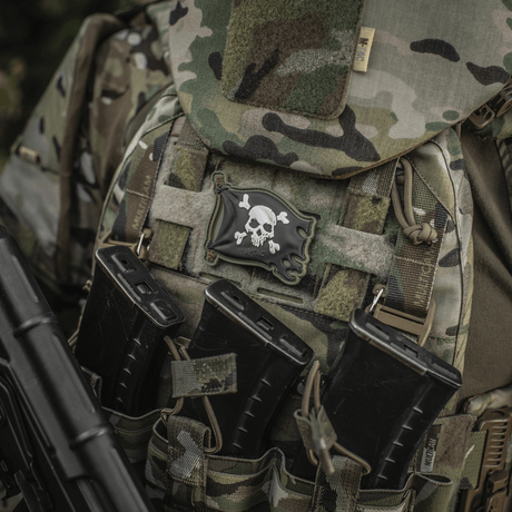 M-Tac Patch Jolly Roger PVC fäst på taktisk ryggsäck med camouflagemönster, symboliserar äventyrslust och beslutsamhet.