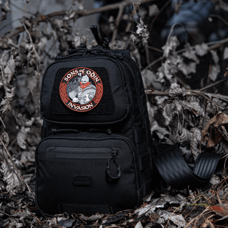 Svart ryggsäck med M-Tac Patch Sons of Odin 3D Velcro i skogsområde, lämplig för taktisk användning och fritid