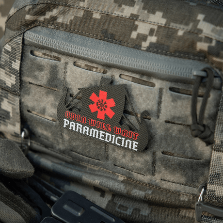 M-Tac Patch Viking Evac på en kamouflagevapenväska med texten "Odin Will Wait Paramedicine".