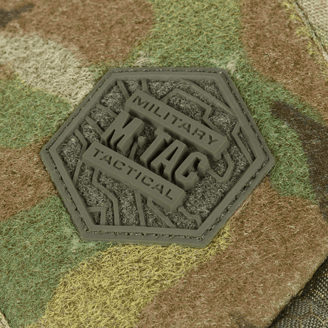 Logotyp på M-Tac Sling pistolväska Elite Hex med Velcro med militär design och camouflagbakgrund.